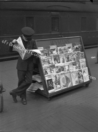 PADDINGTON STATION GWR  NEWS BOY ENJOYING HIS OWN WARES